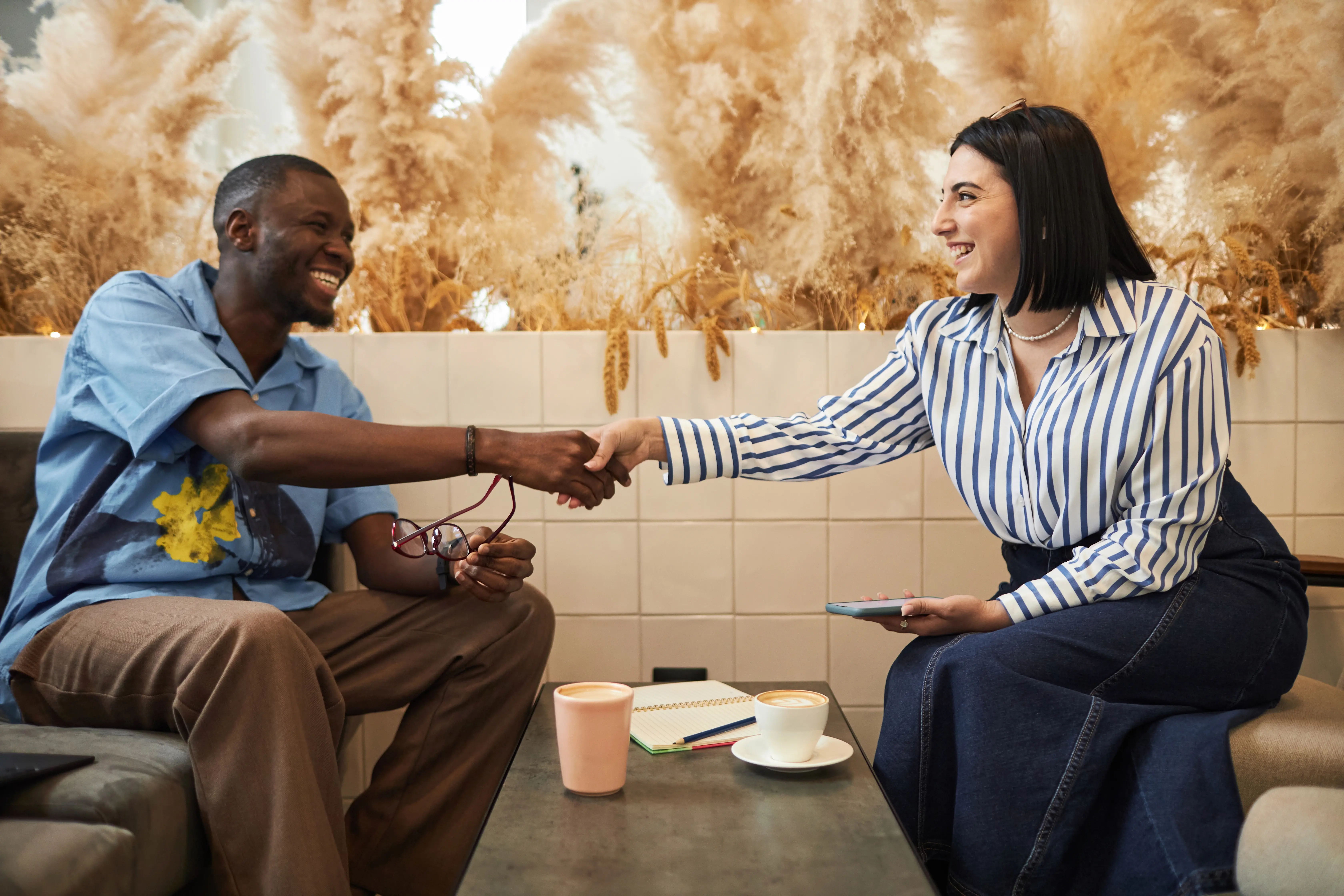 two-smiling-business-people-shaking-hands-2025-03-05-10-22-12-utc